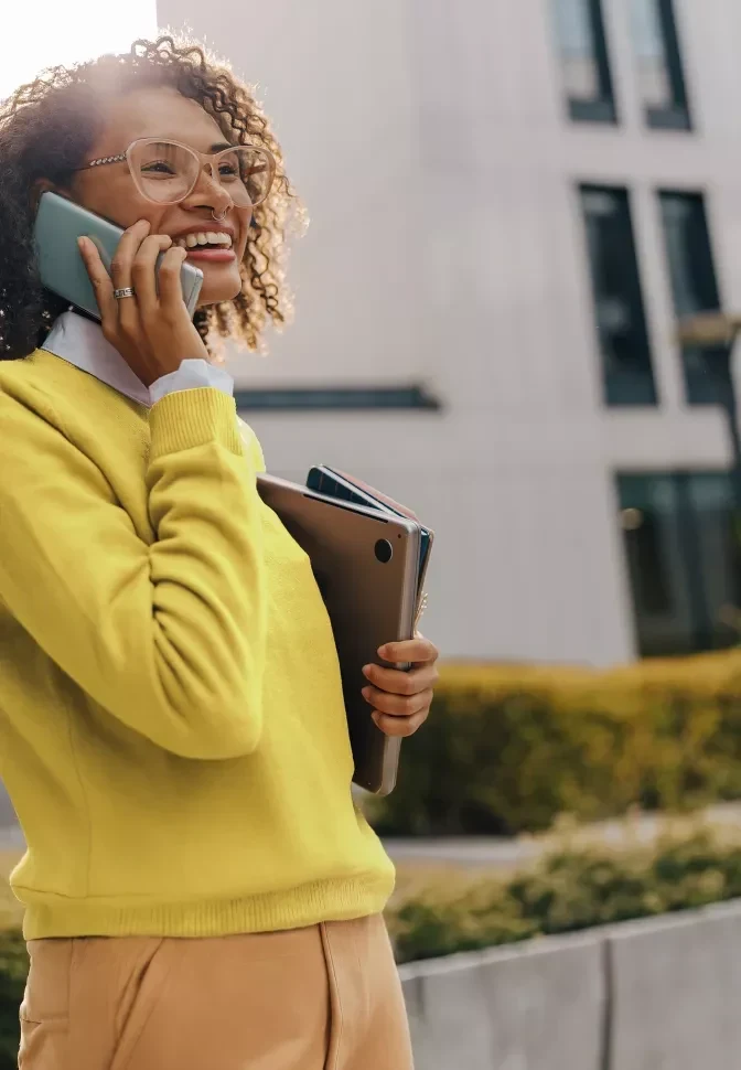 Une femme en tenue de bureau jaune passe un appel.